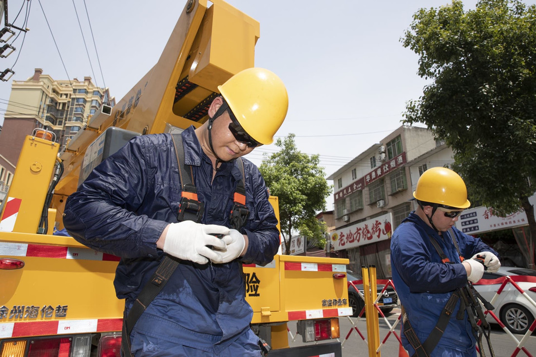 國網(wǎng)綿陽供電公司電力工人結(jié)束帶電作業(yè)，汗水浸透了工裝_副本.jpg